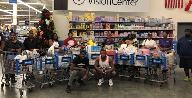 Families with shopping carts alongside Darius Butler and Major Wright